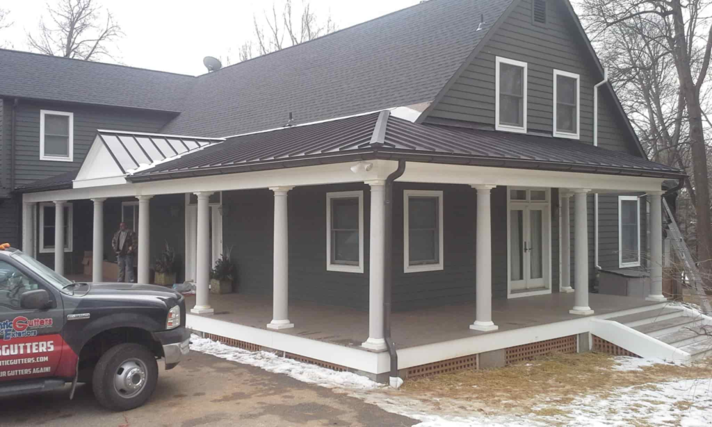 A large house with shingle roof installations in place.