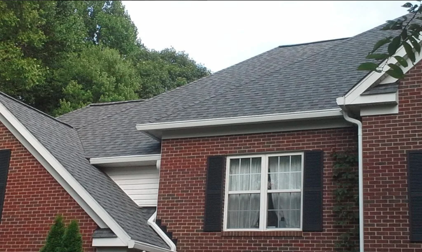 A brick house in Rockville with a gray shingle roof