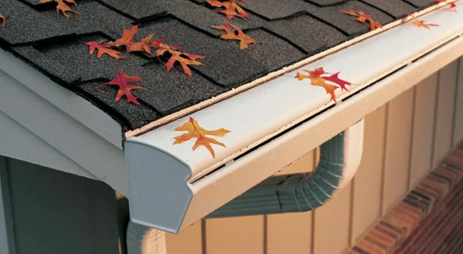 Close-up of a covered gutter system with leaves on top.