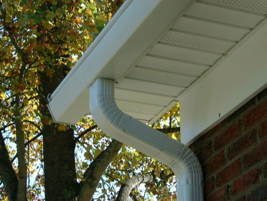 A white gutter system installed along the roofline of a home.